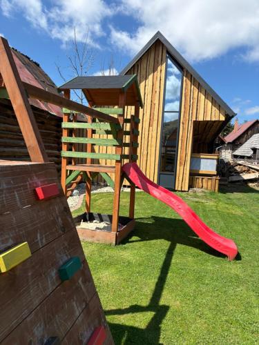 una casa di legno con uno scivolo nell'erba di Chata Pod Úbočou a Liptovská Teplička