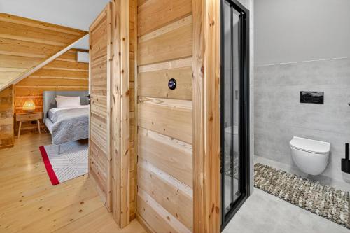 a bathroom with a toilet and a bed in a room at Chalet na vrchoch in Nesluša
