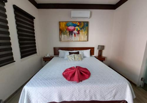 a bedroom with a bed with a red bow on it at Hotel La Ramonna Melaque in San Patricio Melaque