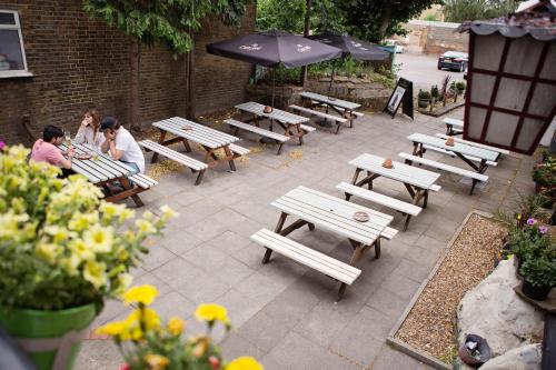 a group of picnic tables and umbrellas on a patio at The Milford Arms in Hounslow