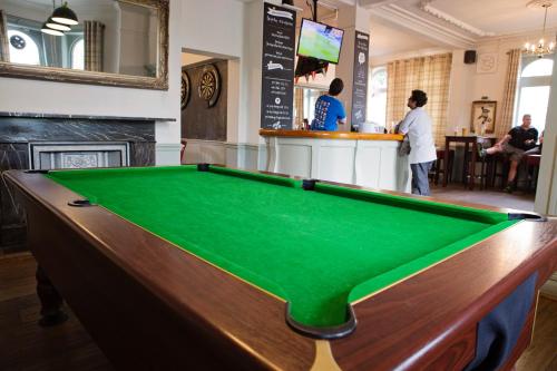 a pool table in a pub with people in a bar at The Milford Arms in Hounslow
