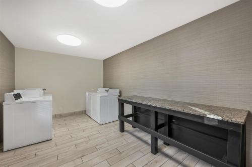 an empty room with a table and washer and dryer at Best Western Columbus Airport in Columbus