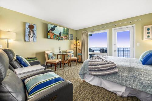 a bedroom with a bed and a couch at Ground Floor Queen Studio - Ocean View - Pool and Hot Tub in Lincoln City