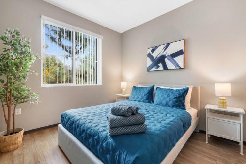 a bedroom with a blue bed and a window at Irvine Luxury Living | Pool, Gym & Prime Location in Irvine