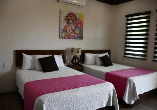 Ένα ή περισσότερα κρεβάτια σε δωμάτιο στο Hotel La Ramonna Melaque