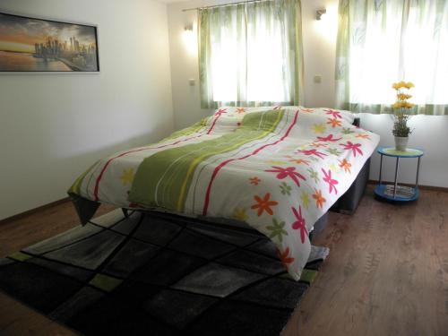 a bedroom with a bed with a colorful comforter at Ausseer Kleeblatt in Bad Aussee