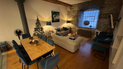 a living room with a christmas tree and a table at ROYAL WILLIAM YARD Luxury Apartments at "THE BRUCE" - FAMILY APARTMENT and Connecting DELUXE STUDIO - PRIVATE connecting lobby so BOOK BOTH For LARGER GROUPS - FREE ONSITE PARKING in Plymouth