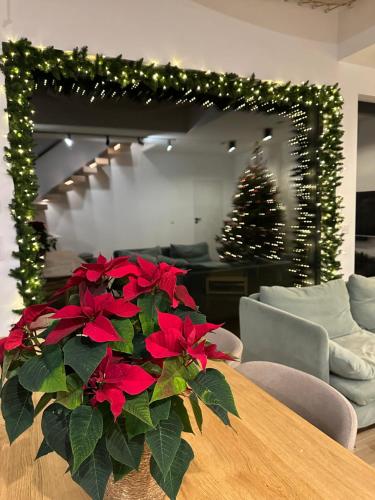 ein Wohnzimmer mit einem Weihnachtsbaum und einem Tisch mit roten Blumen in der Unterkunft Willa Horyzont Borsk in Borsk