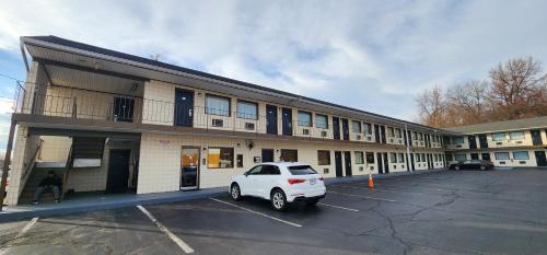 a white car parked in a parking lot in front of a building at Turnpike Motel Richmond VA by Hotel O US 60 in Richmond