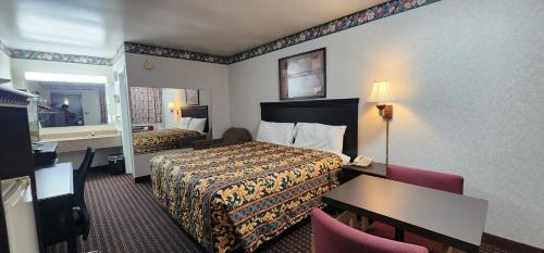 Turnpike Motel Richmond VA by Hotel O US 60 في ريتشموند: غرفة في الفندق بسرير ومكتب وطاولة