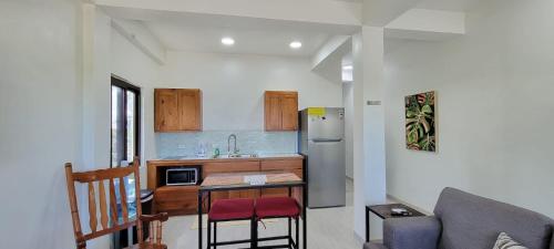 a small kitchen with a table and a refrigerator at Lickety Split 2 - Northside, Oceanview Retreat in Caye Caulker