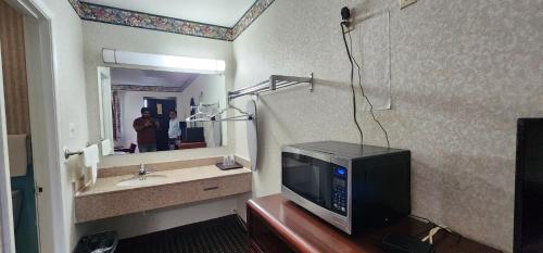 Turnpike Motel Richmond VA by Hotel O US 60 في ريتشموند: جلسة التلفزيون على طاولة في الحمام