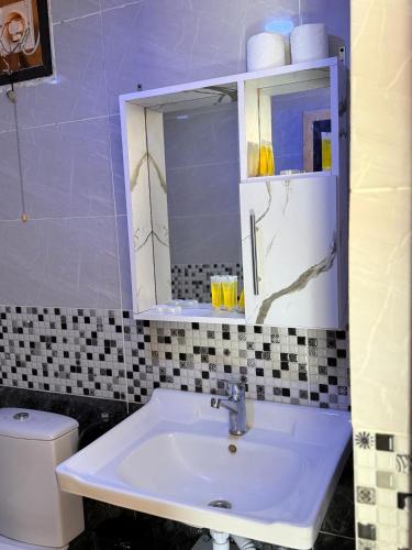 a bathroom with a sink and a mirror and a toilet at Ayla Rum Luxury Camp in Wadi Rum