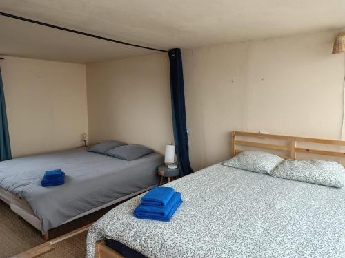ein Schlafzimmer mit zwei Betten mit blauen Handtüchern darauf in der Unterkunft LOFT 2 stations from Paris RER B Laplace in Arcueil