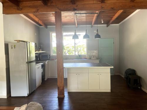 eine Küche mit weißen Schränken und einem Kühlschrank in der Unterkunft Agradable casa con Tina de agua Caliente y Piscina in Quillón