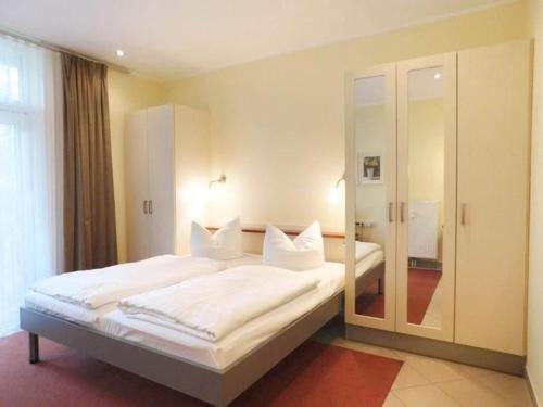 a bedroom with a large bed with white sheets and pillows at Elegant eingerichtete Ferienwohnung in Granzow