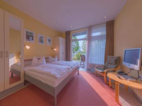 a bedroom with a bed and a desk and a television at Elegant eingerichtete Ferienwohnung in Granzow