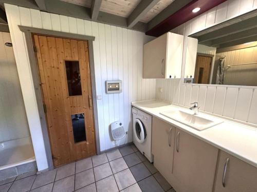a kitchen with a sink and a washing machine at exklusives skandinavisches Ferienhaus in Granzow