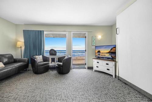 a living room with a couch and a flat screen tv at Oceanfront Family Suite - Full Kitchen - Beach Access - Pool & Hot Tub in Lincoln City