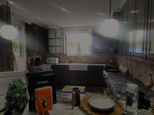 a kitchen with black cabinets and a sink and a window at Hilltop Villa Chez Coco in Rodney Bay Village