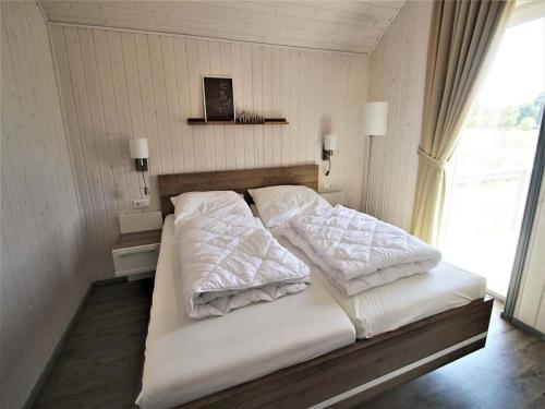 een bed met twee kussens erop in een slaapkamer bij Ferienhaus im skandinavischen Stil in Granzow