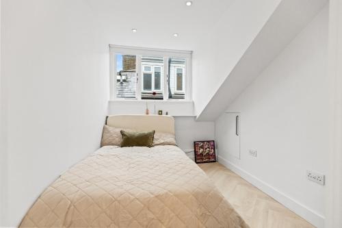 a bedroom with a bed in a white room at Luxury modern 1 bed between Hampstead and Camden in London