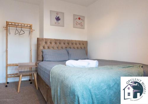 una camera da letto con un letto con un piumone blu di Detached 4 bed - Modern Contractor Pad - Reading a Caversham