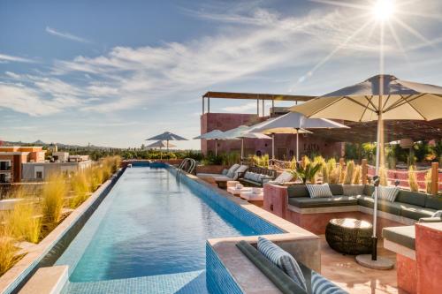an outdoor pool with chairs and umbrellas on top of a building at Laiva Hotel San Jose by Tasman in San José del Cabo