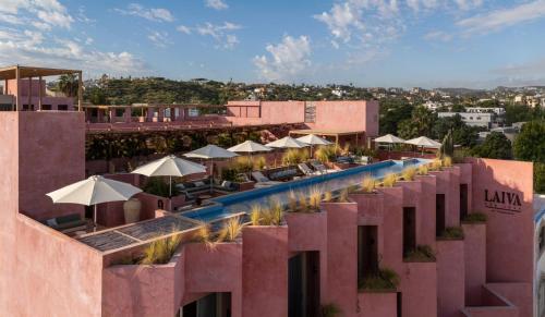 a hotel with a pool with umbrellas and tables at Laiva Hotel San Jose by Tasman in San José del Cabo