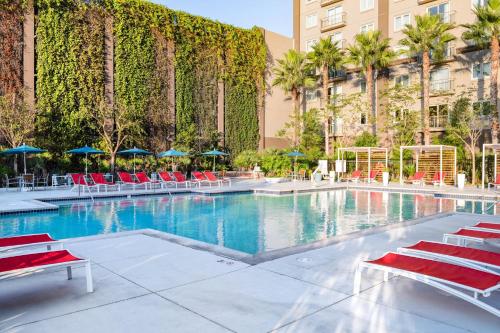 a swimming pool with red chairs and a building at WorldMark Anaheim in Anaheim
