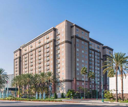 a tall building with palm trees in front of a street at WorldMark Anaheim in Anaheim