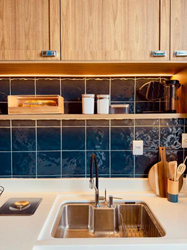 a kitchen with a sink and blue tiles at Ap Da Ilha in Alter do Chao