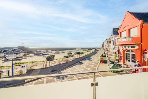 a view of the beach from the balcony of a building at Appartement d’exception face au port de Quiberon in Quiberon
