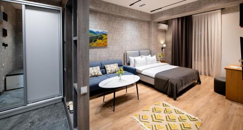 una habitación de hotel con una cama y un sofá en City Deluxe Apartments, en Tashkent