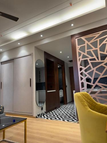 a living room with a yellow chair and a sliding door at Galaxy blue sapphire plaza in Ghaziabad