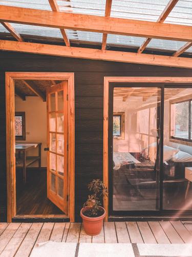 una pantalla en el porche de una casa con una puerta de cristal en Cabaña con vista al volcán, en Neltume