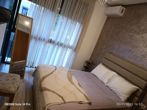 a bedroom with a bed and a large window at Océane palm in Casablanca