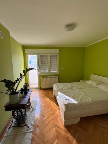 a green bedroom with a bed and a table at KMB suite in Nikšić