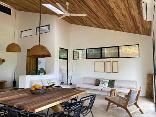 ein Wohnzimmer mit einem Holztisch und einer Couch in der Unterkunft Reserva Atmosfëre in Upala