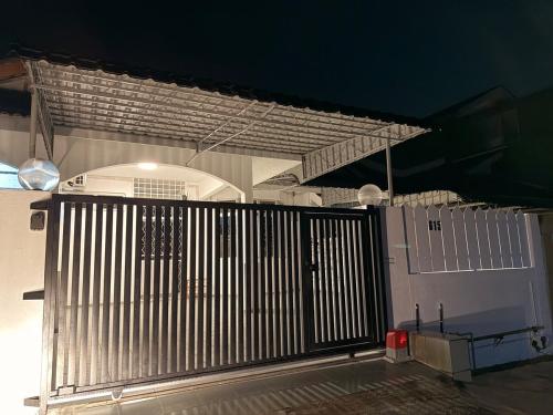 una puerta metálica frente a un edificio en HeyMono #JPO #Senai Airport #IOI mall #Landed #Netflix, en Kampong Saleng