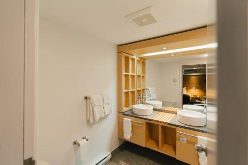 Un baño con dos lavabos y un espejo. en Gîte du Mont-Albert - Sepaq, en Sainte-Anne-des-Monts
