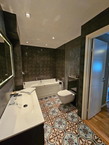 a bathroom with a tub and a toilet and a sink at Downtown apartment in Svolvær in Svolvær