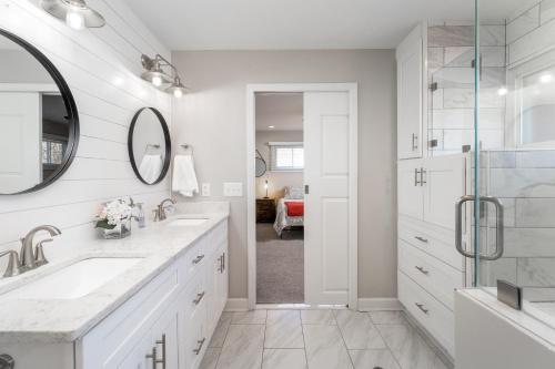 a white bathroom with two sinks and a mirror at Updated 2bed 2bath perfect for golfers, business travelers, and families in Greensboro