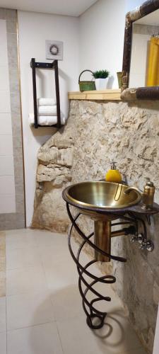 a metal sink in a room with a stone wall at Casa da Pedra - Alvados Porto de Mós, Leiria in Alvados