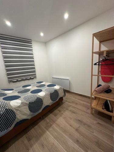 a bedroom with a bed and a wooden floor at Appartement Douceur in Horbourg