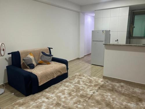 Una sala de estar con un sofá y una cocina. en Entre Mar e Morros, Apto praia Pontal Recreio, en Río de Janeiro