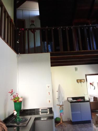 a kitchen with a stove and a staircase at Hostel pousada floresta in Joinville