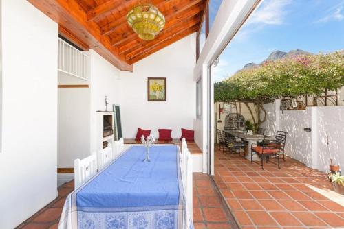 a house with a blue table on a patio at Authentic Cape Dutch Gem - Relax & Unwind in Cape Town