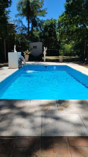 a blue swimming pool with a water fountain at jardin de lourdes in Corrientes