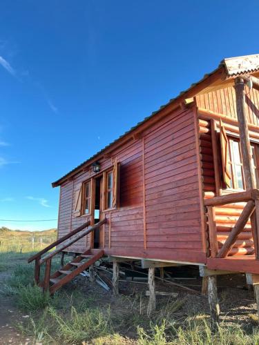 una casa di legno su tronchi in un campo di Olivillos II a Balneario Pehuén-Có